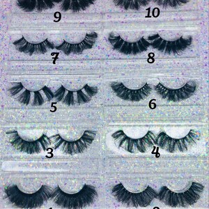 May include: A collection of ten pairs of black false eyelashes, each in a clear plastic case. The lashes vary in style, with some appearing fuller and longer than others. Numbers 1 through 10 are printed on the cases, indicating different designs.