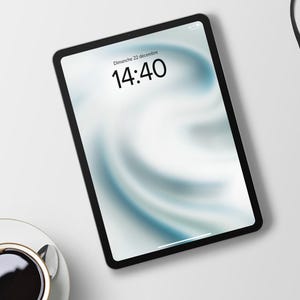Puede incluir: Una tableta negra con un fondo blanco y un reloj digital que muestra las 14:40. El texto "Dimanche 22 decembre" se muestra encima del reloj.