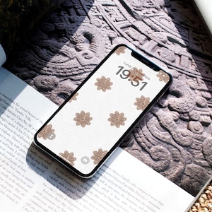 May include: A smartphone with a white background and a brown floral pattern. The time is 19:51 and the date is Lundi 20 Septembre.