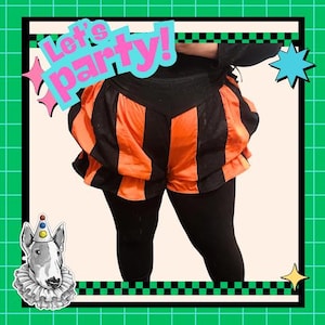 May include: Black and orange striped pumpkin-style shorts with a high waistband, worn over solid black leggings. The image features the text Let's party! in blue and pink, along with a graphic of a dog wearing a clown hat and a ruffled collar.