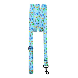 May include: A light blue dog leash featuring a repeating pattern of purple squiggly lines, orange geometric shapes, green triangles, and blue circles. The leash includes a black metal swivel snap hook at one end and an adjustable black plastic slider.