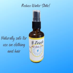 May include: A brown glass bottle with a yellow label that says "B-Frizzle Anti-Static Spray". The bottle has a black spray nozzle and is on a blue background. The text "Reduce Winter Static!" is at the top of the image. The text "Naturally safe for use on clothing and hair" is on the left side of the image.
