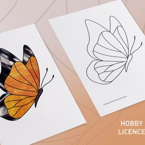 May include: Two white sheets of paper with butterfly designs. One sheet features a stained glass butterfly with orange and black wings. The other sheet has a black outline of a butterfly. The text "HOBBY LICENCE" is visible.