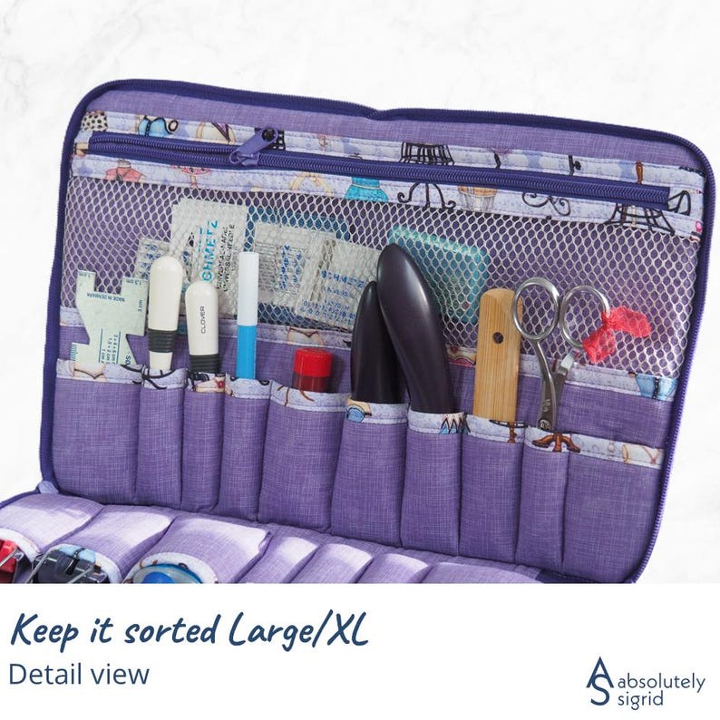 Pode incluir: Um organizador de tecido roxo com v&aacute;rios bolsos e um compartimento de malha, ideal para guardar materiais de costura. O organizador est&aacute; aberto, revelando v&aacute;rias ferramentas como tesouras, canetas e frascos pequenos. O texto "Keep it sorted Large/XL" &eacute; vis&iacute;vel.