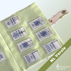 Puede incluir: Un estuche organizador de tela verde claro que contiene varios estuches de plástico transparente con agujas para máquina de coser Schmetz. El organizador tiene una solapa con estampado floral y cierre de broche. El texto NL Versie es visible.