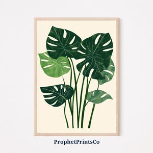 May include: A digital illustration of a cluster of green monstera leaves on a cream background. The leaves are dark green with lighter green veins and edges. The illustration is framed with a light wood frame.