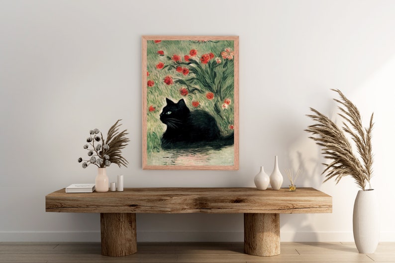 K&ouml;nnte beinhalten: Ein gerahmter Druck eines schwarzen Katers, der in einem Feld mit roten Blumen sitzt. Die Katze hat blaue Augen und schaut nach links. Die Blumen bl&uuml;hen und der Hintergrund ist ein gr&uuml;nes Feld.