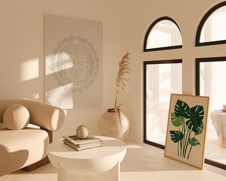 May include: A white couch with a beige cushion sits in a room with a large window, a framed print of tropical leaves, and a canvas print of a Buddha face.
