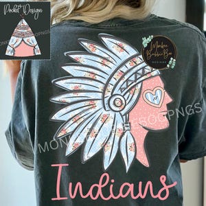 Könnte beinhalten: Dunkelgraues T-Shirt mit einem Design eines indianischen Kopfschmucks mit floralen Akzenten und dem Wort "Indians" in rosa Schrift. Das Design zeigt ein Profil mit herzförmigem Gesicht und blau-weißem Kopfschmuck.