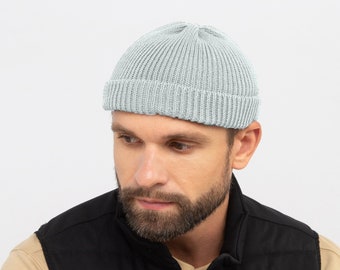 May include: A light blue ribbed knit beanie. The hat is a close-fitting style, with a folded brim. The beanie is made of a soft, textured material. The background is a plain white.