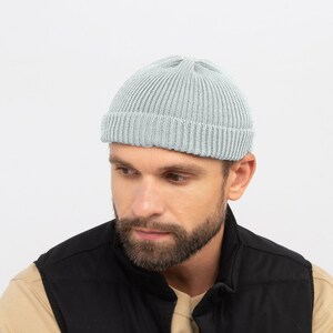 May include: A light blue ribbed knit beanie. The hat is a close-fitting style, with a folded brim. The beanie is made of a soft, textured material. The background is a plain white.
