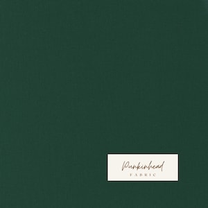 May include: Dark green fabric with a textured surface. A white rectangular label in the lower right corner features the text "Punkinhead" in a cursive font, with "FABRIC" below it.