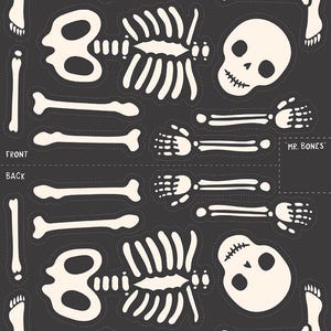 May include: A sheet of cream-colored skeleton cutouts on a dark gray background. The design includes a skull, rib cage, arm and leg bones, and the text "MR. BONES". The cutouts are outlined with a dotted line.
