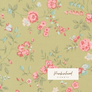 May include: A light olive green fabric featuring a repeating floral pattern with pink roses, small light blue blossoms, and green leaves. A white rectangular label in the bottom right corner displays the text Punkinhead FABRIC.