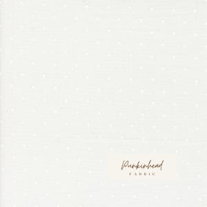 May include: Off-white fabric with a subtle polka dot pattern. The fabric has a soft texture and a delicate appearance. The words "Punkinhead Fabric" are printed in a cursive font.