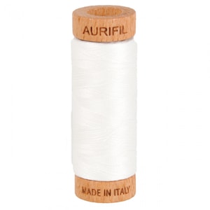 May include: A spool of white thread with a wooden bobbin. The bobbin is labeled "Aurifil" and "Made in Italy".