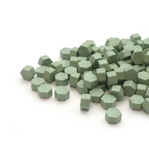 May include: A pile of green wax sealing pellets, shaped like hexagons, for sealing envelopes or letters.