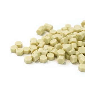 May include: A pile of small, hexagonal, light beige wax seals.