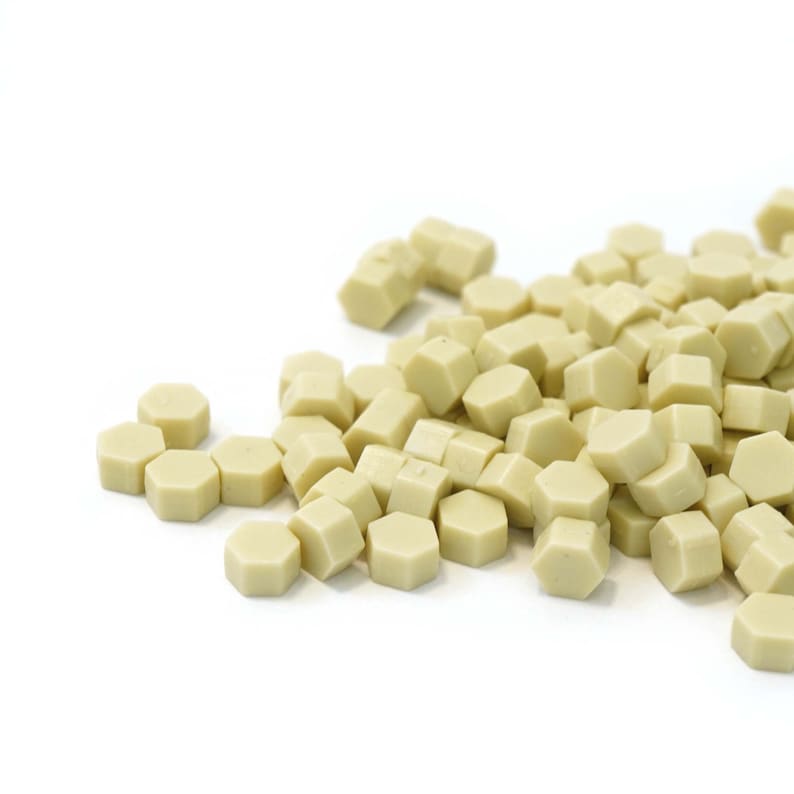 May include: A pile of small, hexagonal, light beige wax seals.