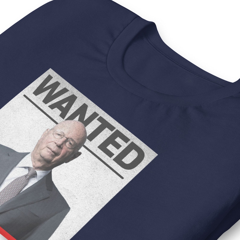 May include: A navy blue t-shirt with a white poster that says "WANTED" and features a photo of a man in a suit and tie.