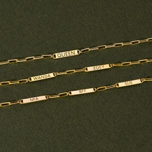 Puede incluir: Cuatro pulseras de cadena dorada con placas de nombre personalizadas. Las placas de nombre dicen "QUEEN", "ZOEY", "WANDA", "MIA", "BFF" y "SUE".