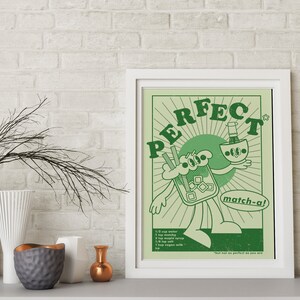 May include: A framed art print with a retro cartoon design in shades of green. The artwork features a character holding a matcha drink, with the word "PERFECT" above. The recipe is listed below the character.