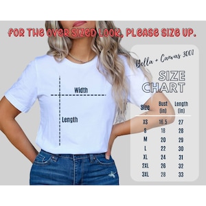 以下が含まれることがあります： 幅と長さの寸法が記載された白いTシャツのサイズ表。表には、XSから3XLまでのサイズが記載されており、バストと着丈の寸法はインチで表示されています。