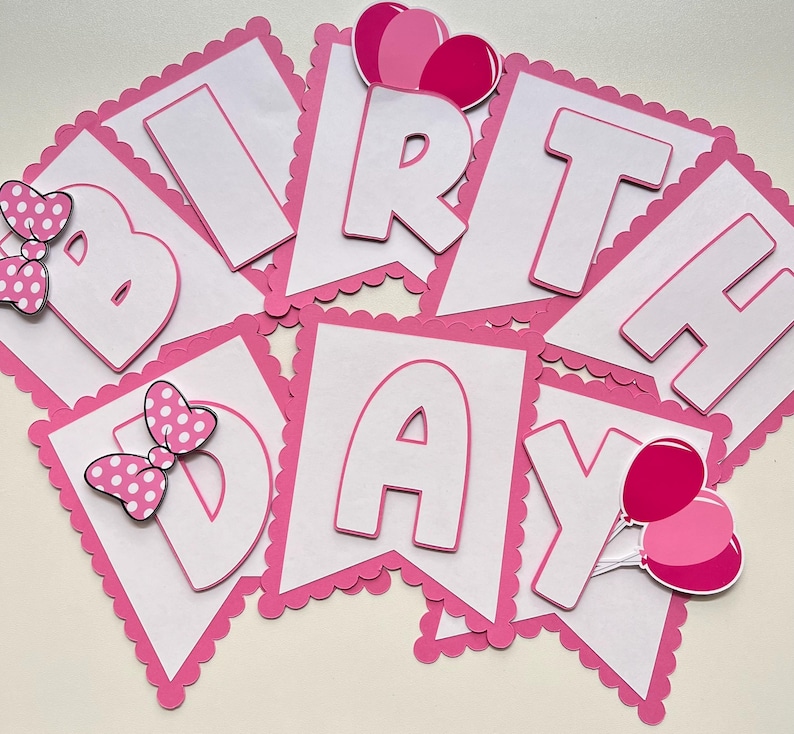May include: Pink and white birthday banner with the word "Birthday" in white letters on pink flags. Each flag has a scalloped edge. The flags are decorated with pink bows and balloons.