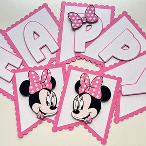 May include: Pink and white banner with the word "Happy" in white letters and two images of Minnie Mouse with pink polka dot bows.