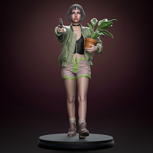 May include: A detailed figurine of a woman holding a gun and a potted plant. She wears a green bomber jacket, striped shorts, and boots. The figure stands on a black circular base against a dark background. The woman has short dark hair and a choker.