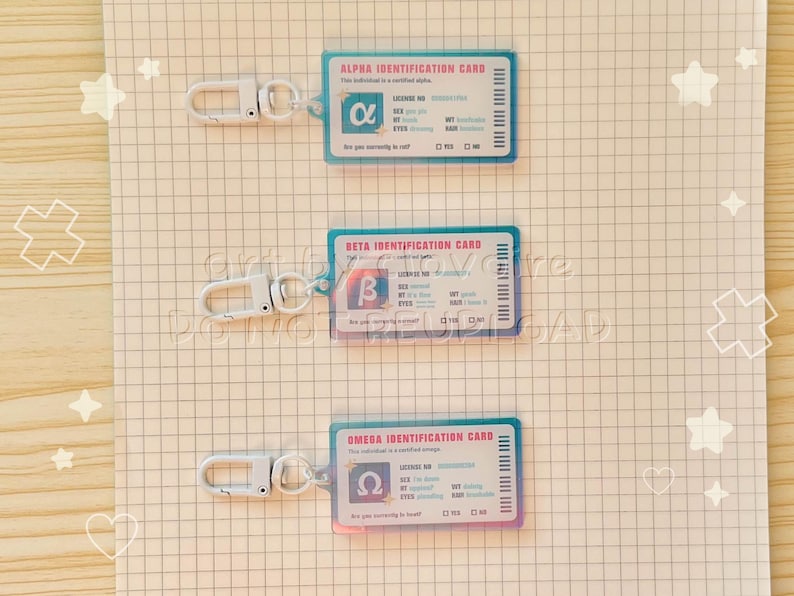 May include: Three clear plastic ID cards with silver keychains. Each card has a different Greek letter: Alpha, Beta, and Omega. The cards have a blue border and include text such as "Identification Card" and "License No."