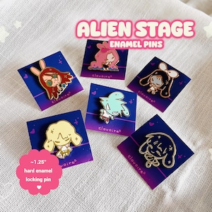 May include: Six hard enamel locking pins, each around 3.2 cm, showcasing anime-style character designs. The pins are presented on blue and purple gradient cards, with the text "ALIEN STAGE ENAMEL PINS".