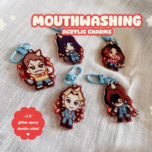 Peut inclure: Ensemble de cinq breloques acryliques recto-verso avec des personnages de dessins animés. Chaque breloque mesure environ 5 cm et possède une finition époxy pailletée. Elles sont attachées à des porte-clés bleus. Le texte "MOUTHWASHING" et "ACRYLIC CHARMS" est visible.