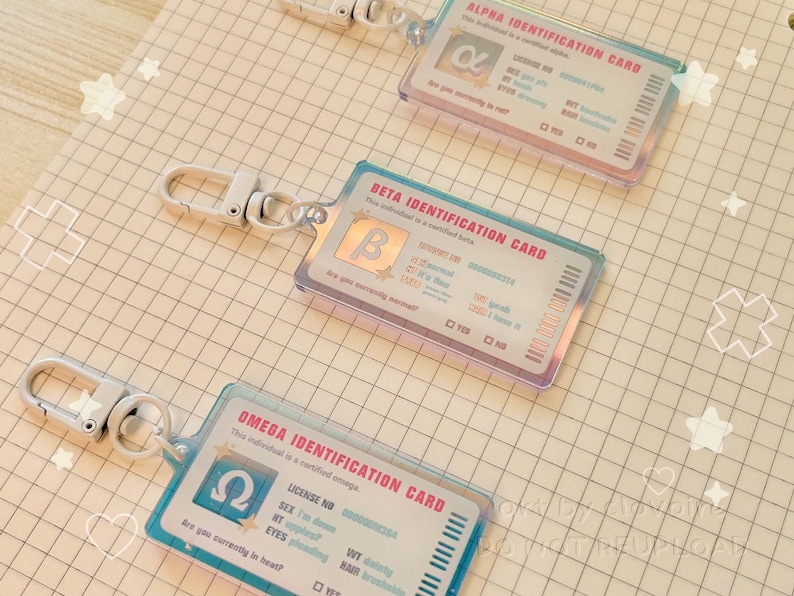 May include: Three ID card keychains with iridescent edges. Each card has a different Greek letter: Alpha, Beta, and Omega. The cards have a clear plastic overlay and a silver clasp. The cards have text including "Identification Card" and other details.