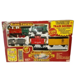 May include: A boxed G gauge Grand Canyon Express radio control train set. The set includes a red and green locomotive, several train cars, and a remote control. The box features text that reads "Train Sounds" and "40 Piece Train Set".