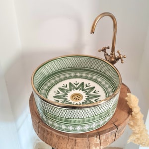 Lavabo in ceramica verde fatto a mano con bordo in ottone: elemento centrale per il bagno.