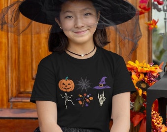 Könnte beinhalten: Eine Person in einem Halloween-Hexenkostüm, mit einem schwarzen Hexenhut und einem schwarzen T-Shirt mit Halloween-Grafiken. Sie hält eine schwarze Katzensüßigkeitentüte. Das Outfit umfasst einen schwarzen Rock, gestreifte Leggings und schwarze Turnschuhe.