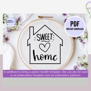 May include: A black and white embroidery template featuring a house with the text "SWEET HOME" and a heart inside the house. The template is displayed on a white embroidery hoop.