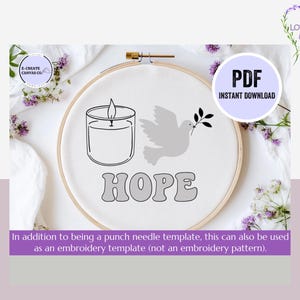 May include: A white embroidery hoop with a black line drawing of a candle, a dove, and the word "HOPE" in a retro font. The hoop is on a white surface with purple flowers.