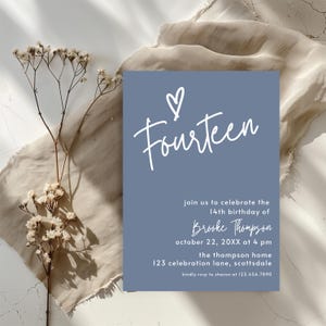 Peut inclure: Une carte d'invitation bleue avec le mot "Fourteen" en &eacute;criture blanche, surmont&eacute;e d'un c&oelig;ur. La carte annonce le 14e anniversaire de Brooke Thompson, avec la date, l'heure et le lieu. Fleurs s&eacute;ch&eacute;es et tissu en arri&egrave;re-plan.