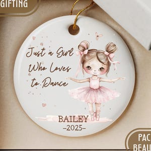 May include: A white ceramic ornament with a ballerina illustration and the text "Just a Girl Who Loves to Dance." The ornament includes the name "BAILEY" and the year "-2025-". It is packaged in a gift box.