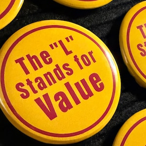 May include: Yellow button with a red border and the text "The 'L' stands for Value". The buttons are round and have a glossy finish. The background is dark.