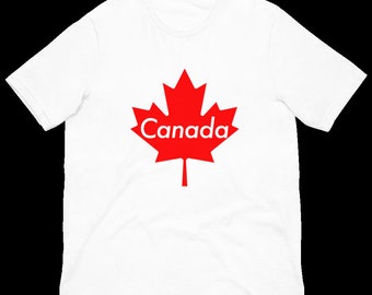 Peut inclure: T-shirt blanc avec une feuille d'érable rouge et le mot "Canada" imprimé dessus.