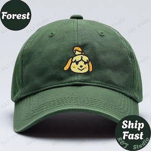 May include: A dark green baseball cap with a curved peak. The cap has an embroidered yellow and tan cartoon character on the front. The word "Forest" is printed on a dark green circle on the left side of the cap.