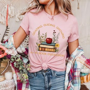 Maglietta "A+ in Book Obsession" - Maglietta autunnale per insegnanti con pila di mele / Regalo floreale per bibliotecari e amanti dei libri