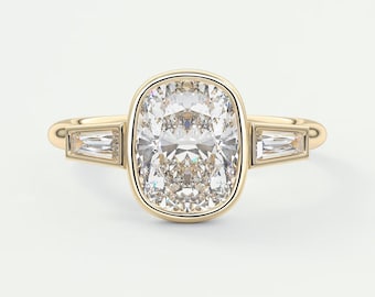 May include: A gold engagement ring with a large, cushion-cut diamond set in a bezel setting. The diamond is surrounded by a halo of smaller diamonds. Two baguette-cut diamonds are set on either side of the center stone.