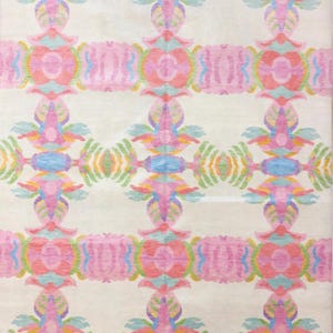 Handmade modern wool rug with pastel pink, lavender, blue, green, and yellow geometric botanical motifs on an ivory background.