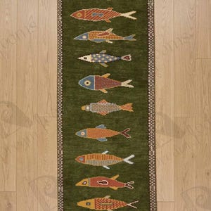 May include: A long, rectangular green rug with a repeating pattern of colorful fish. The fish are in various colors, including red, blue, yellow, and orange, and are arranged in a vertical row. The rug has a decorative border.