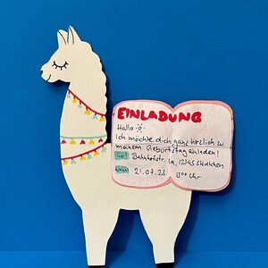 K&ouml;nnte beinhalten: Ein wei&szlig;es Lama mit einem rosa Buch, auf dem "EINLADUNG" steht und der Text "Hallo - Ich m&ouml;chte dich ganz herzlich zu meinem Geburtstag einladen! Wo? Bahnhofstr. 19, 12345 St&auml;dtchen Wann? 21.07.23 1300 Uhr" zu lesen ist.
