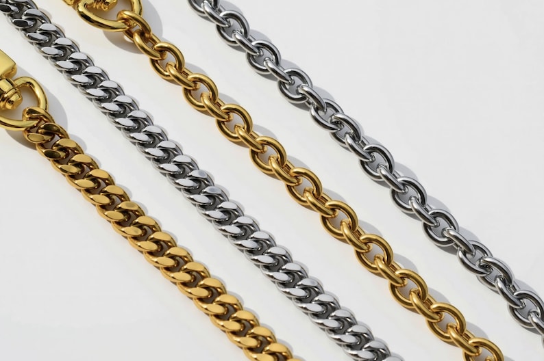 a close-up view of several metal chain necklaces with different colored links, including gold, silver, and white.